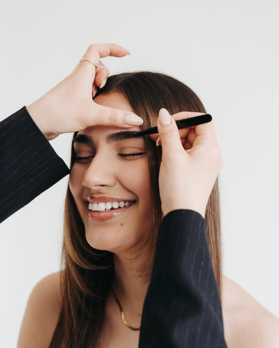 Client getting her brows shaped by Niki